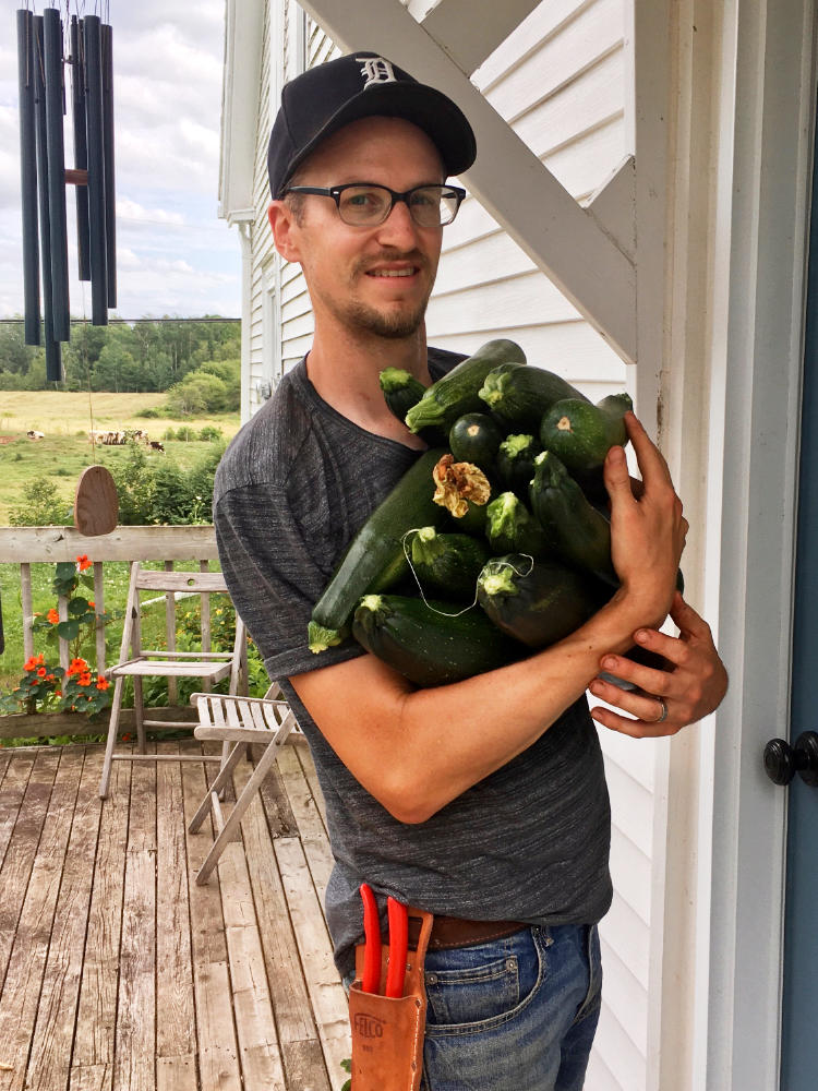 Calvin Schnurr at house door with armload of zucchini
