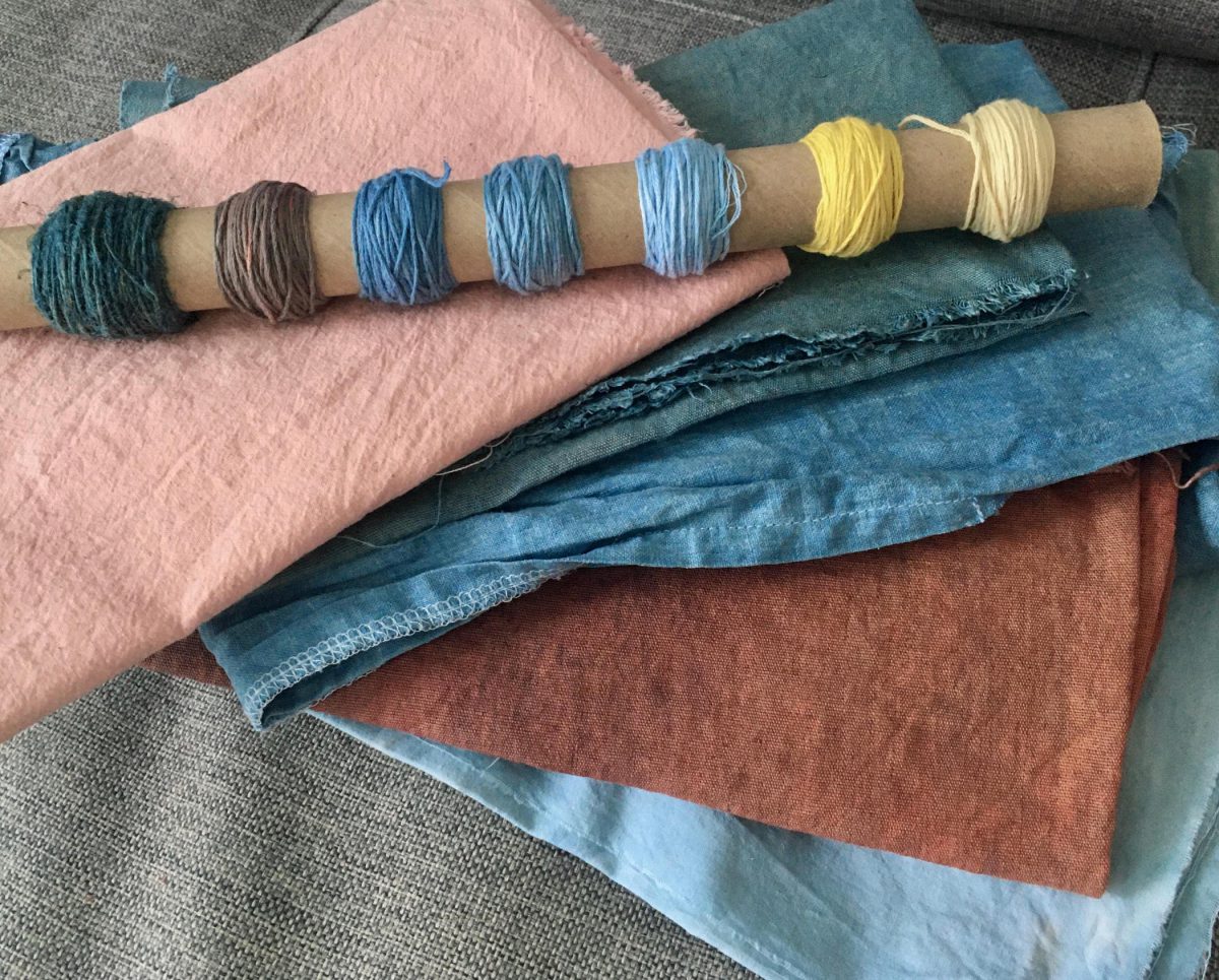 Textiles and embroidery thread dyed in pinks, blues, reds, and yellows